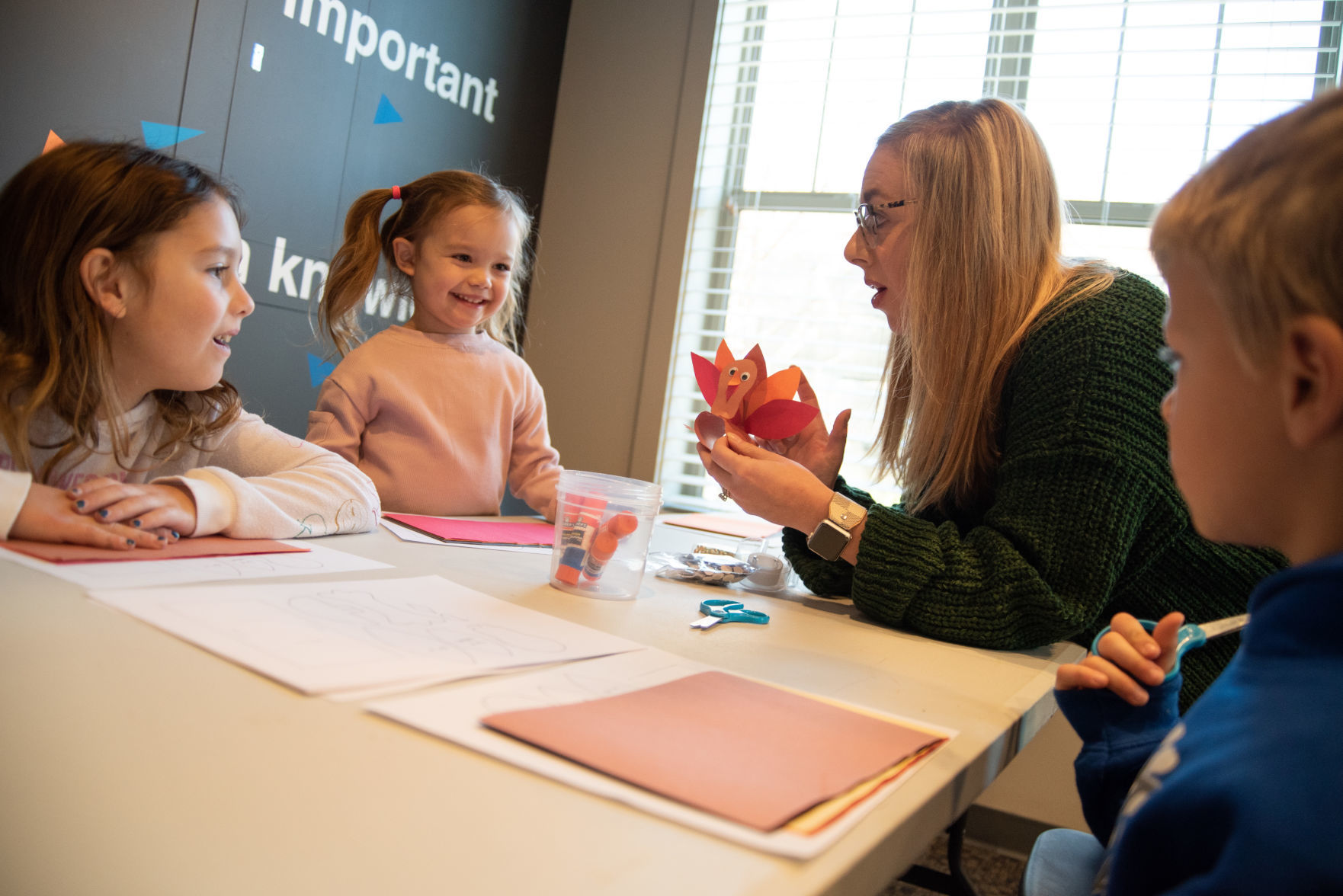 Kasey Kilewilksinson, owner of ieDiscoveries, shows Madison Easton, 6, Abigail Kanter, 4, and Wyatt Goerl, 6, the turkey craft